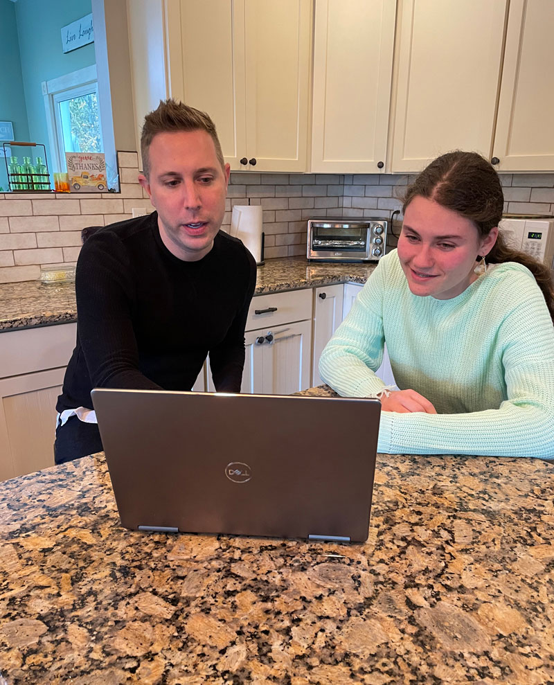 Daniel and student working on laptop